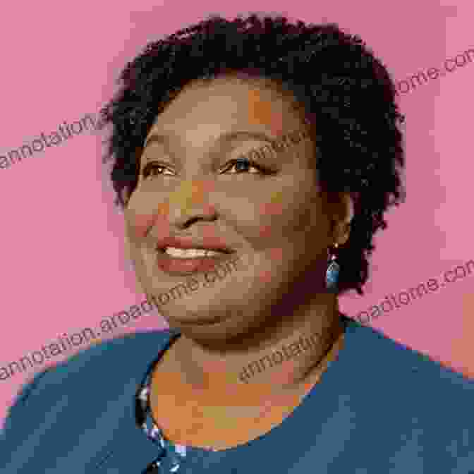 A Portrait Of Stacey Abrams, A Woman With Dark Skin, Short Hair, And A Warm Smile. She Is Wearing A Blue Blouse And A Pendant Necklace. Stacey Abrams Book: The Biography Of Stacey Abrams